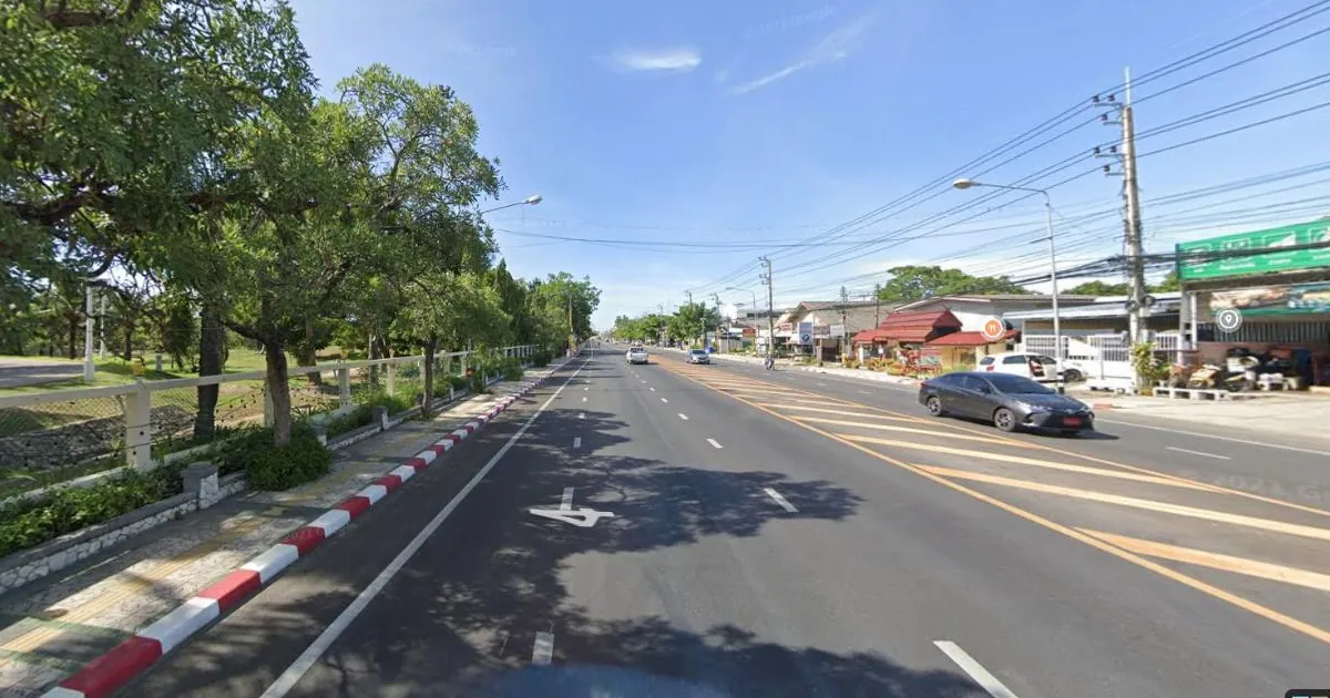 Phetkasem Road with the white fence of Klai Kangwon Palace on the left